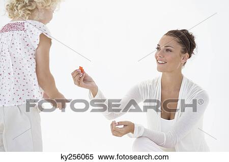 Woman giving flowers to her daughter View Large Photo Image Stock Photography - Woman giving flowers to her daughter. Fotosearch