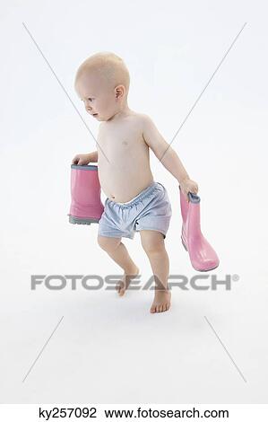 Baby boy carrying a pair of rubber boots View Large Photo Image Stock Image - Baby boy carrying a pair of rubber boots. Fotosearch