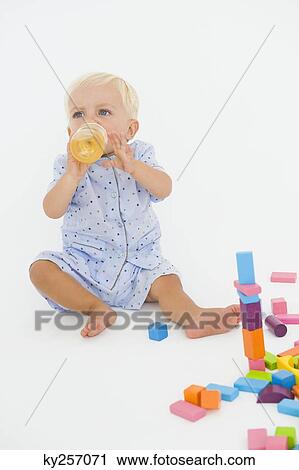 Stock Image - Baby boy drinking juice from a baby bottle. Fotosearch