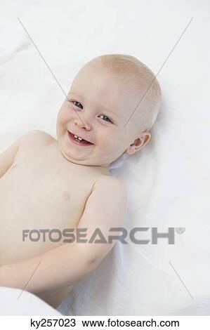 Baby boy lying on the bed and smiling View Large Photo Image Stock Image - Baby boy lying on the bed and smiling. Fotosearch