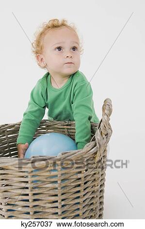 Baby boy picking a balloon from a wicker basket View Large Photo Image Stock Photo - Baby boy picking a balloon from a wicker basket. Fotosearch