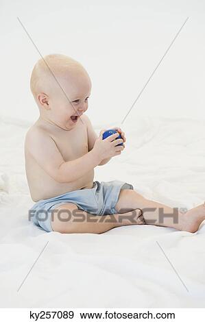 Baby boy playing with a ball View Large Photo Image Stock Photo - Baby boy playing with a ball. Fotosearch