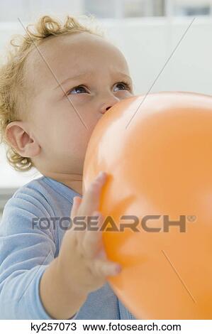 Baby boy playing with a balloon View Large Photo Image Stock Image - Baby boy playing with a balloon. Fotosearch