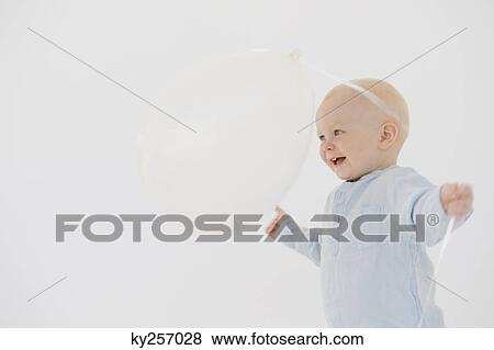 Baby boy playing with a balloon View Large Photo Image Stock Photo - Baby boy playing with a balloon. Fotosearch