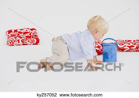 Baby boy playing with a watering can View Large Photo Image Stock Image - Baby boy playing with a watering can. Fotosearch