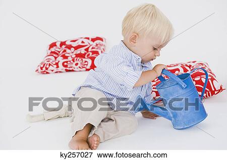 Stock Photo - Baby boy playing with a watering can. Fotosearch