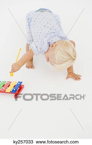 Stock Image - Baby boy playing with a xylophone. Fotosearch
