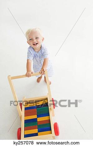 Baby boy pushing a cart View Large Photo Image Stock Photo - Baby boy pushing a cart. Fotosearch