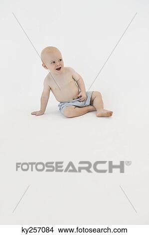 Baby boy sitting on the floor and smiling View Large Photo Image Picture - Baby boy sitting on the floor and smiling. Fotosearch