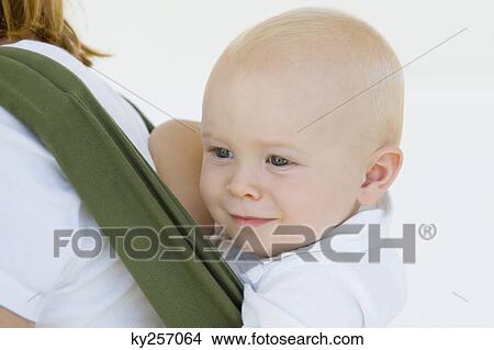 Woman carrying her son in a baby carrier View Large Photo Image Picture - Woman carrying her son in a baby carrier. Fotosearch