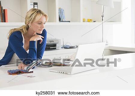 Stock Image - Businesswoman choosing color swatches. Fotosearch
