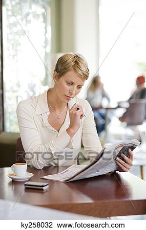 Businesswoman sitting in a restaurant and reading a financial newspaper View Large Photo Image Stock Image - Businesswoman sitting in a restaurant and reading a financial newspaper. Fotosearch
