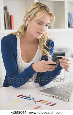Businesswoman text messaging on a mobile phone View Large Photo Image Picture - Businesswoman text messaging on a mobile phone. Fotosearch