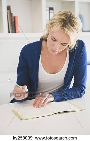 Businesswoman writing on a notepad View Large Photo Image Stock Photo - Businesswoman writing on a notepad. Fotosearch