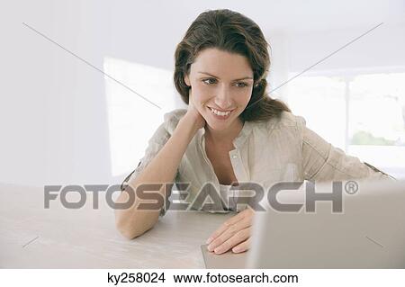 Woman looking at a laptop View Large Photo Image Picture - Woman looking at a laptop. Fotosearch