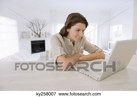 Woman looking at a laptop View Large Photo Image Stock Photo - Woman looking at a laptop. Fotosearch
