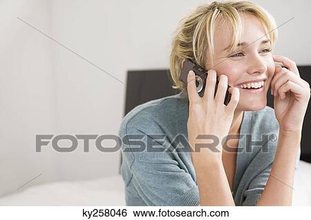 Woman talking on a mobile phone View Large Photo Image Stock Photograph - Woman talking on a mobile phone. Fotosearch