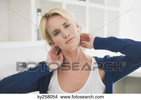 Woman touching her neck View Large Photo Image Picture - Woman touching her neck. Fotosearch