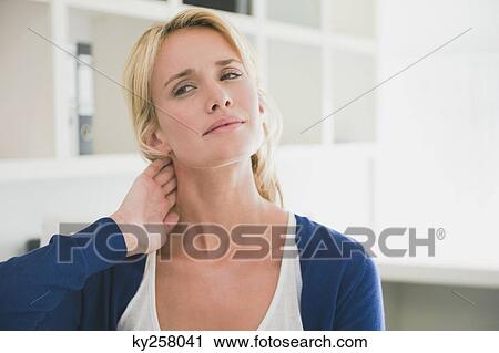 Woman touching her neck View Large Photo Image Stock Image - Woman touching her neck. Fotosearch