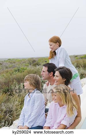 Family sitting at the poolside and admiring the view View Large Photo Image Picture - Family sitting at the poolside and admiring the view. Fotosearch