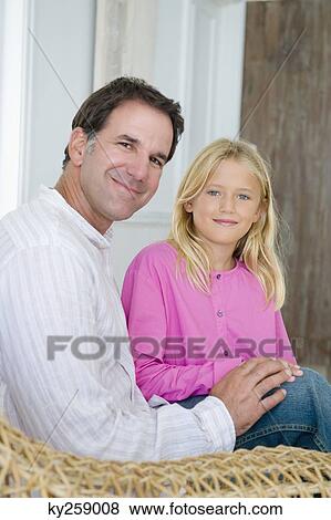 Portrait of a man sitting with his daughter View Large Photo Image Stock Photo - Portrait of a man sitting with his daughter. Fotosearch