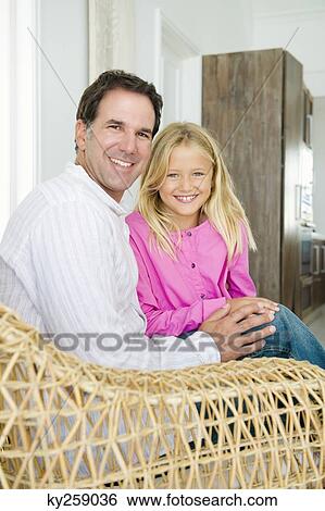 Portrait of a man sitting with his daughter View Large Photo Image Stock Photograph - Portrait of a man sitting with his daughter. Fotosearch