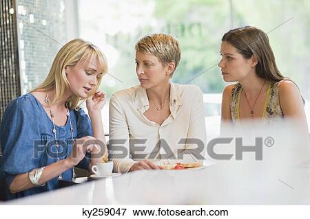 Stock Photo - Three women sitting in a restaurant. Fotosearch