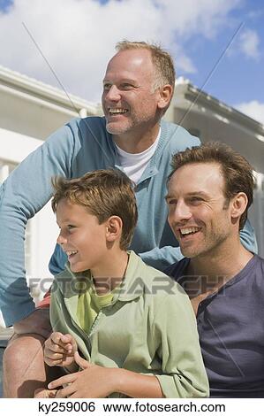 Two men smiling with a boy View Large Photo Image Stock Photograph - Two men smiling with a boy. Fotosearch