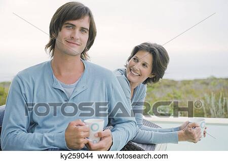 Woman and her son drinking tea at the poolside View Large Photo Image Picture - Woman and her son drinking tea at the poolside. Fotosearch