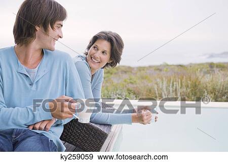 Woman and her son drinking tea at the poolside View Large Photo Image Stock Photo - Woman and her son drinking tea at the poolside. Fotosearch