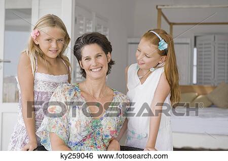 Woman smiling with her two daughters View Large Photo Image Stock Photograph - Woman smiling with her two daughters. Fotosearch