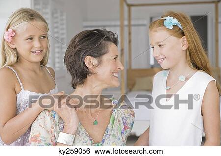 Woman smiling with her two daughters View Large Photo Image Stock Photograph - Woman smiling with her two daughters. Fotosearch