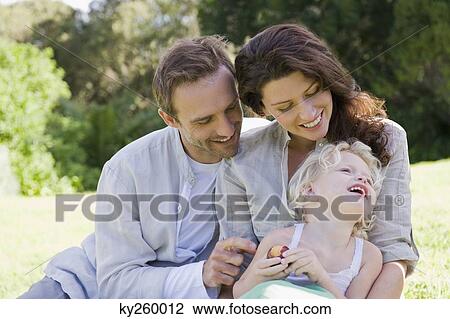 Stock Image - Family smiling in a lawn. Fotosearch