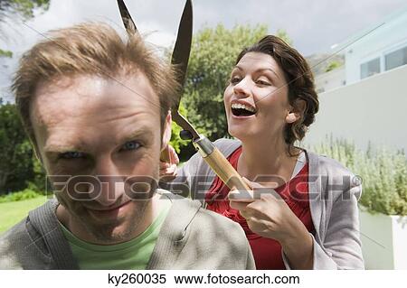 Woman cutting man's hair with a hedge clipper View Large Photo Image Stock Photography - Woman cutting man's hair with a hedge clipper. Fotosearch