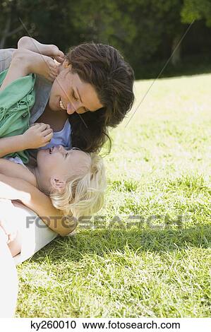 Stock Image - Woman playing with her daughter in a lawn. Fotosearch