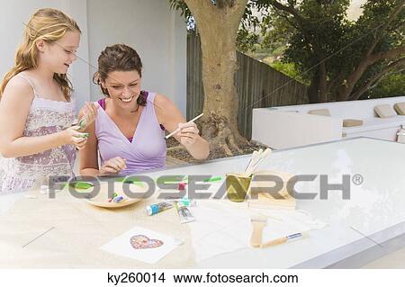 Woman teaching her daughter View Large Photo Image Picture - Woman teaching her daughter. Fotosearch