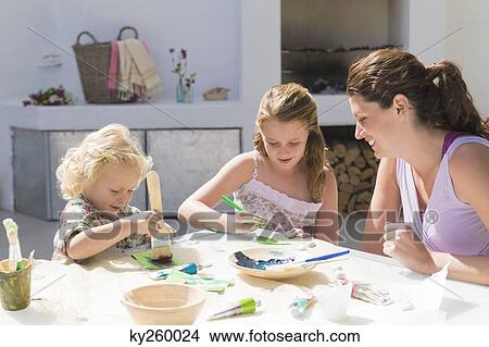 Woman teaching her two daughters View Large Photo Image Picture - Woman teaching her two daughters. Fotosearch