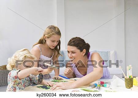 Woman teaching her two daughters View Large Photo Image Picture - Woman teaching her two daughters. Fotosearch