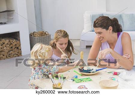 Stock Image - Woman teaching her two daughters. Fotosearch