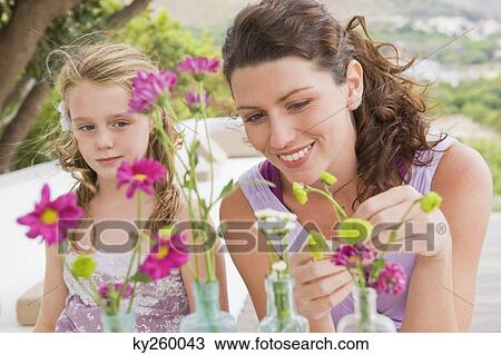 Woman with her daughter arranging flowers in a vase View Large Photo Image Stock Image - Woman with her daughter arranging flowers in a vase. Fotosearch