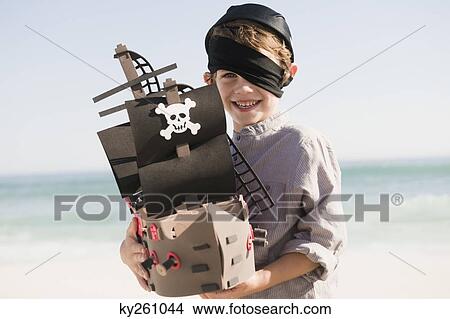 Boy in pirate costume playing with a toy boat View Large Photo Image Picture - Boy in pirate costume playing with a toy boat. Fotosearch