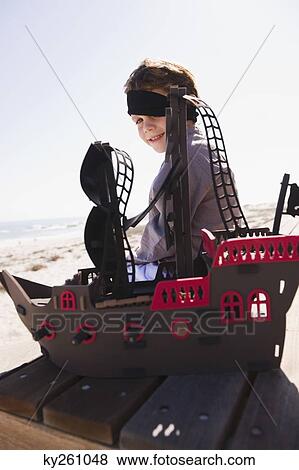 Boy in pirate costume playing with a toy boat View Large Photo Image Stock Photo - Boy in pirate costume playing with a toy boat. Fotosearch