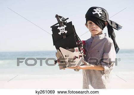 Boy in pirate costume playing with a toy boat View Large Photo Image Stock Photo - Boy in pirate costume playing with a toy boat. Fotosearch