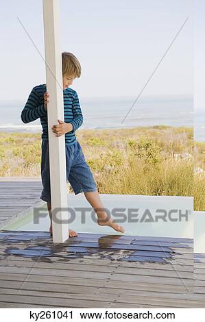Boy standing at the poolside View Large Photo Image Stock Image - Boy standing at the poolside. Fotosearch