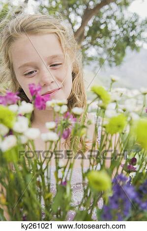 Girl looking at flowers View Large Photo Image Stock Image - Girl looking at flowers. Fotosearch