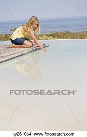 Girl playing on a platform at an infinity pool View Large Photo Image Picture - Girl playing on a platform at an infinity pool. Fotosearch