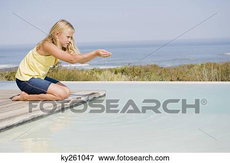 Girl playing on a platform at an infinity pool View Large Photo Image Stock Photo - Girl playing on a platform at an infinity pool. Fotosearch