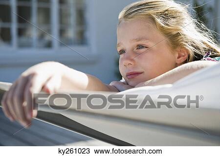 Stock Image - Girl resting on a deck chair. Fotosearch