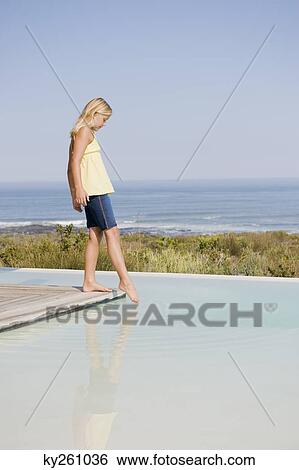 Girl standing on a platform at an infinity pool View Large Photo Image Stock Photograph - Girl standing on a platform at an infinity pool. Fotosearch