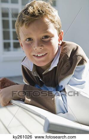 Portrait of a boy resting on a deck chair View Large Photo Image Stock Photograph - Portrait of a boy resting on a deck chair. Fotosearch